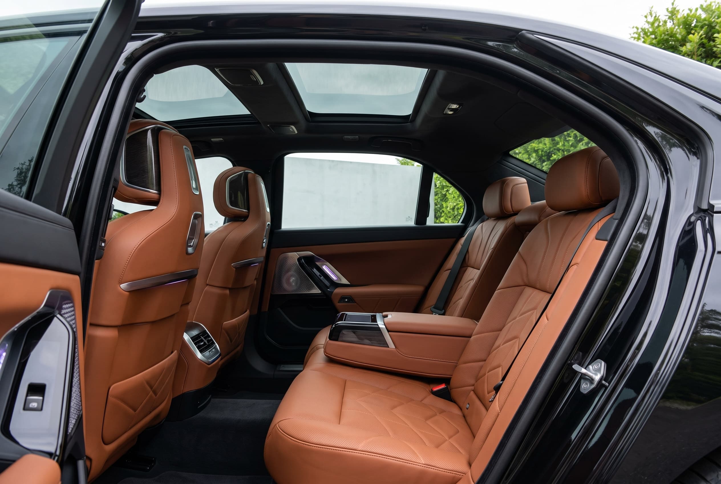 Cognac leather rear seats and panoramic roof of a BMW 7 Series seen through the open door