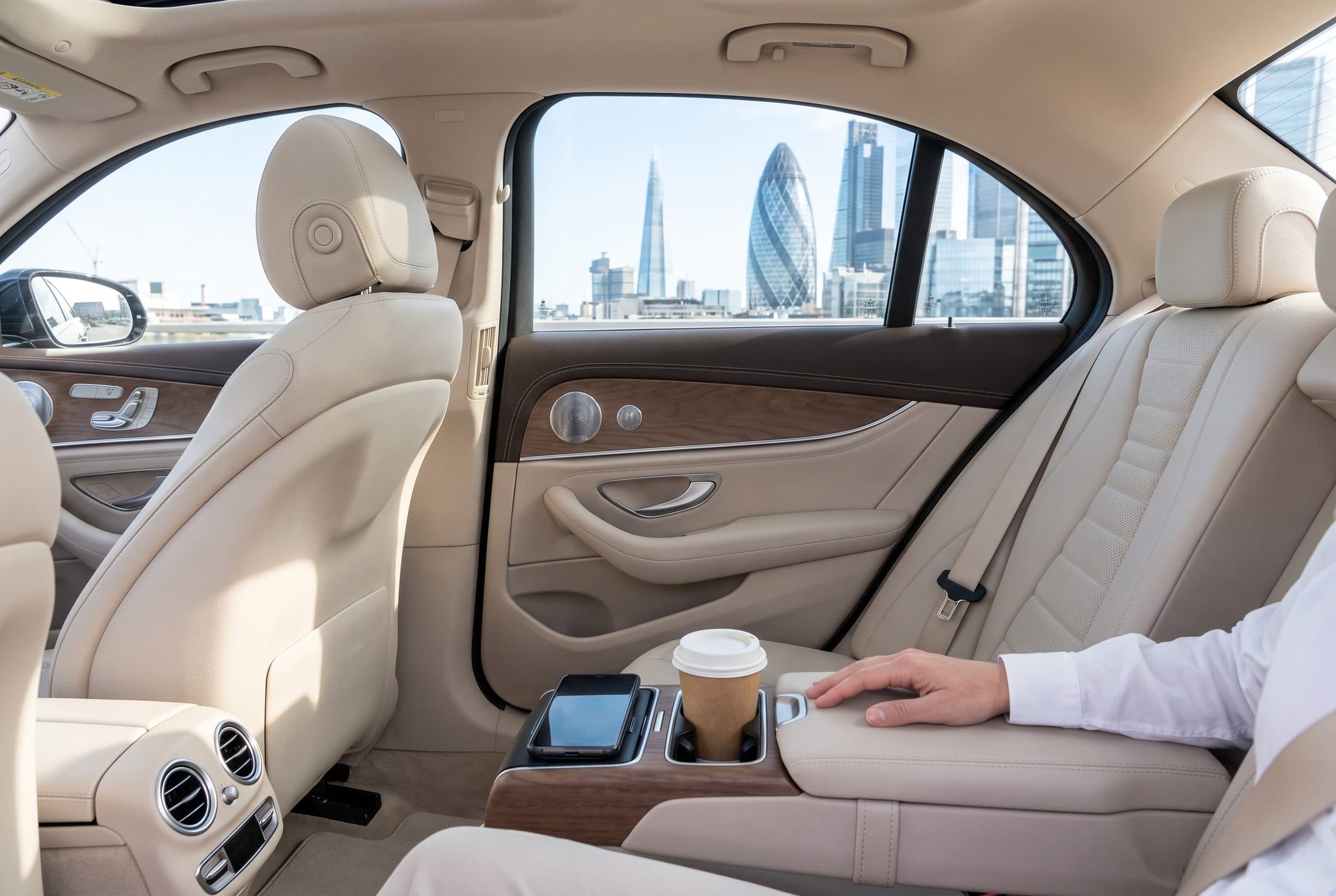 Cream leather rear seat of a Mercedes E-Class with the City of London skyline outside